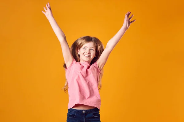 黄色を背景に腕を伸ばして空気中で精力的な男の子の女の子のスタジオショット — ストック写真