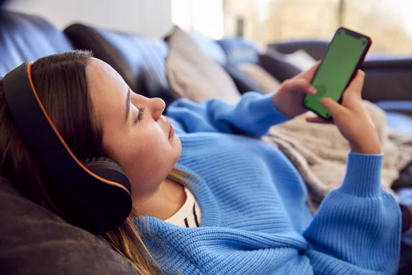 Teenagermädchen Liegt Auf Sofa Und Trägt Drahtlose Kopfhörer Die Hause — Stockfoto