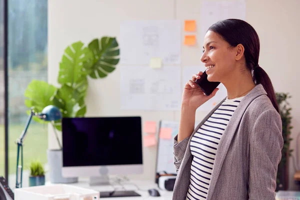 Kvinnlig Arkitekt Arbetar Stående Office Talar Mobiltelefon — Stockfoto