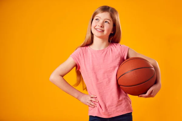 Estúdio Tiro Menina Segurando Basquete Sob Braço Contra Fundo Amarelo — Fotografia de Stock