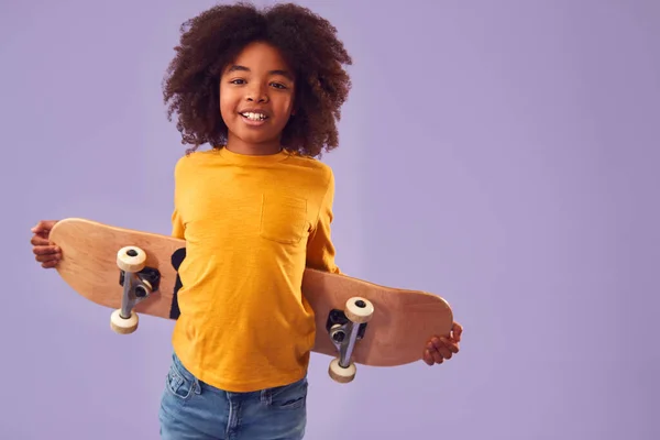 Studio Portrét Mladého Chlapce Drží Skateboard Zády Proti Fialové Pozadí — Stock fotografie