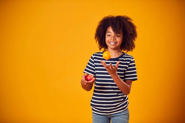 Studioporträt Eines Jungen Der Vor Gelbem Hintergrund Mit Apfel Und — Stockfoto