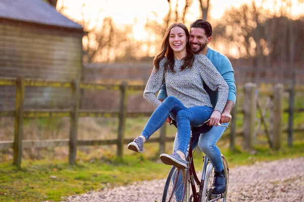 Pareja Montando Bicicleta Través Del Campo Con Mujer Sentada Manillar — Foto de Stock