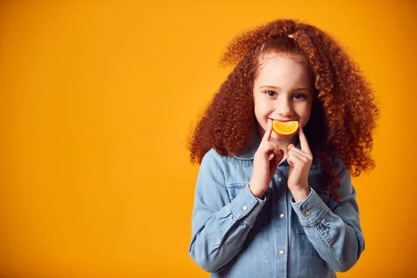 Studioporträt Eines Mädchens Mit Orangefarbenem Lächeln Vor Gelbem Hintergrund — Stockfoto