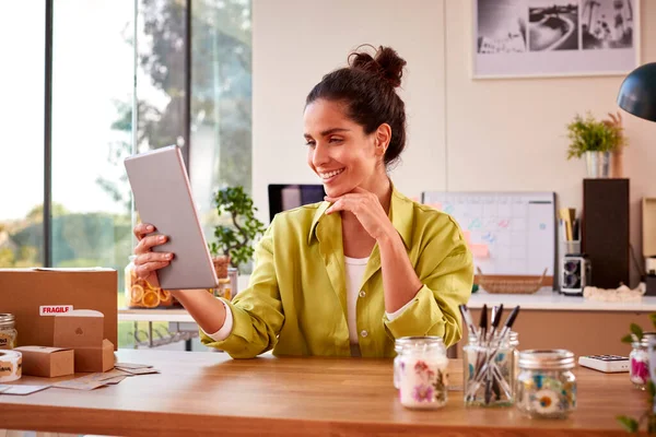 Woman Running Online Business Making Boutique Candles At Home Having Video Call On Digital Tablet