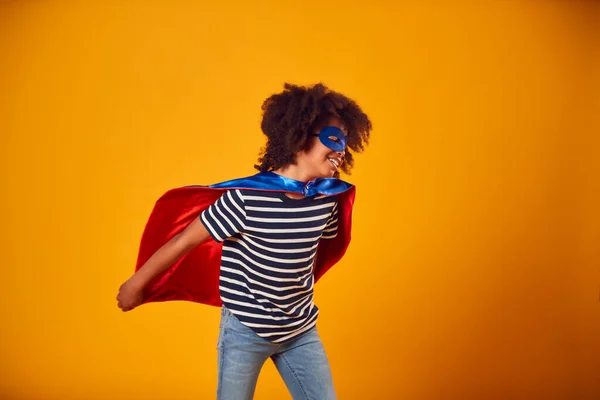 黄色の背景に漫画の本のスーパーヒーローとして身に着けている男の子のスタジオ肖像画 — ストック写真