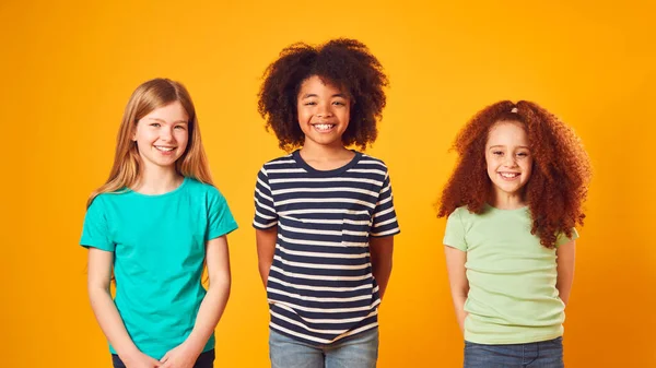 Estúdio Retrato Tiro Três Crianças Amigos Contra Fundo Amarelo — Fotografia de Stock