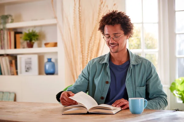 Man Ontspannen Thuis Zitten Aan Tafel Lezen Boek Met Warme — Stockfoto