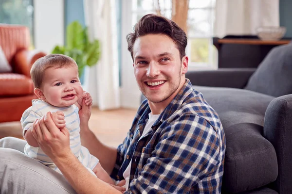 自宅で床に座って赤ちゃんの息子と遊ぶ愛するトランスジェンダーの父 — ストック写真