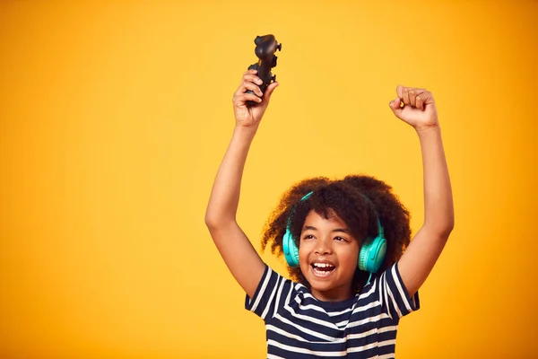 Studio Strzał Uśmiechnięty Młody Chłopiec Noszący Słuchawki Gry Kontrolerem Żółtym — Zdjęcie stockowe