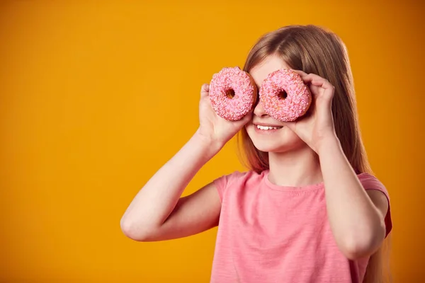 Студийный Портрет Девушки Держащей Два Пончика Перед Глазами Жёлтом Фоне — стоковое фото