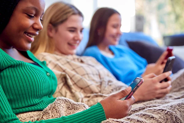 Group Multi Cultural Teenage Girl Friends Snuggled Blanket Looking Mobile — Stock Photo, Image