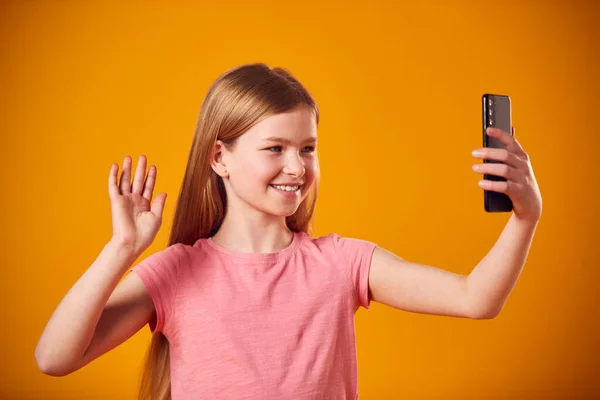 Студийный Портрет Молодой Девушки Позирующей Селфи Мобильном Телефоне Жёлтом Фоне — стоковое фото