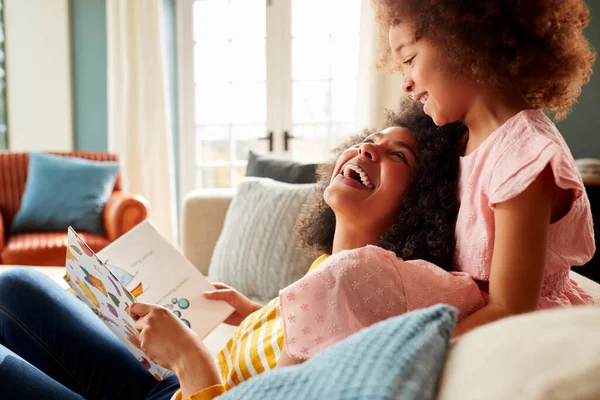 Μητέρα Και Κόρη Χαλαρώνοντας Στον Καναπέ Στο Σπίτι Διαβάζοντας Βιβλίο — Φωτογραφία Αρχείου