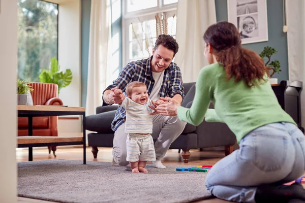 Famiglia Transgender Incoraggiare Bambino Fare Primi Passi Nella Lounge Casa — Foto Stock