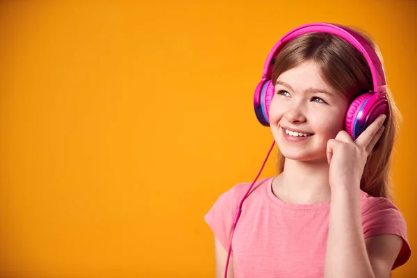 Studio Shot Smiling Young Girl Luisteren Naar Muziek Hoofdtelefoon Tegen — Stockfoto