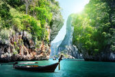 langes Boot und Felsen am Strand in Krabi, Thailand