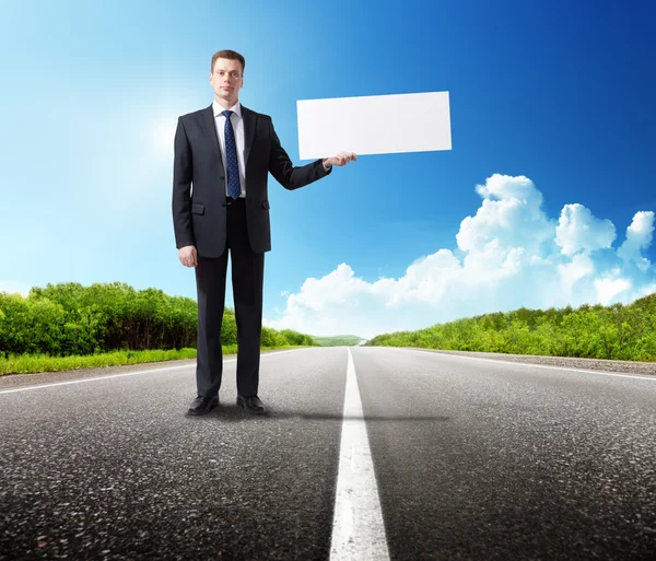 Business man on the road whith blank in hand — Stock Photo, Image