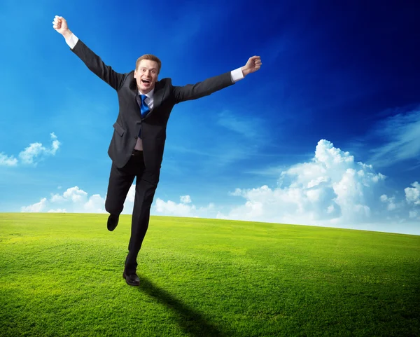 Homem de negócios feliz correndo no campo de primavera — Fotografia de Stock