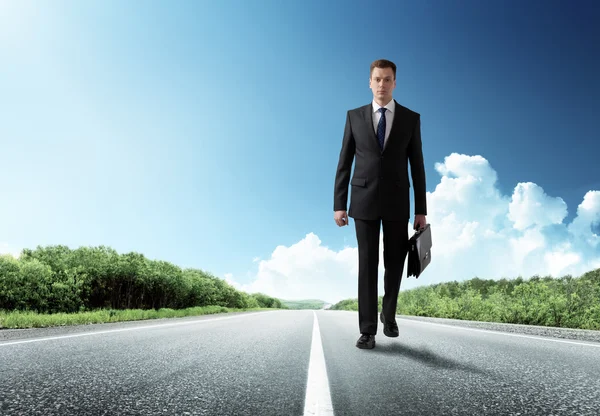 Business man walking on the road — Stock Photo, Image