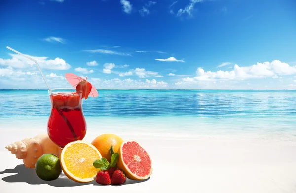 Клубничный коктейль и тропические фрукты на пляже — стоковое фото