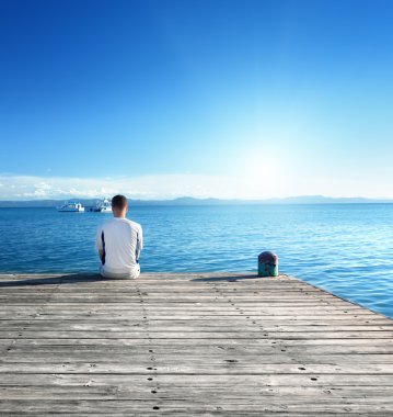 jonge man ontspannen aanbrengen op pier