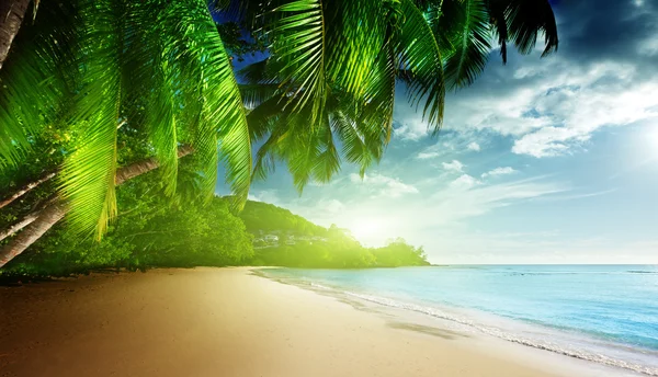 Pôr do sol na praia Anse Takamaka da ilha de Mahe, Seychelles — Fotografia de Stock