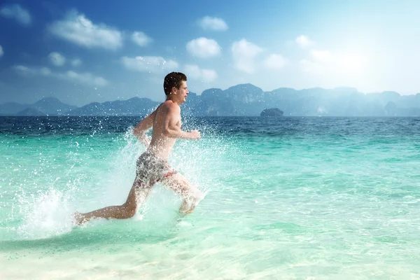 熱帯の海の水で男を実行します。 — ストック写真