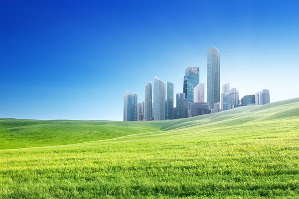 Spring field and modern city — Stock Photo, Image