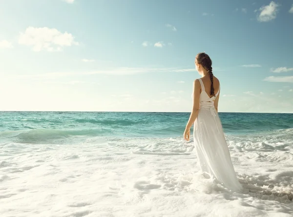 Joven mujer de pie en olas del mar — Foto de Stock