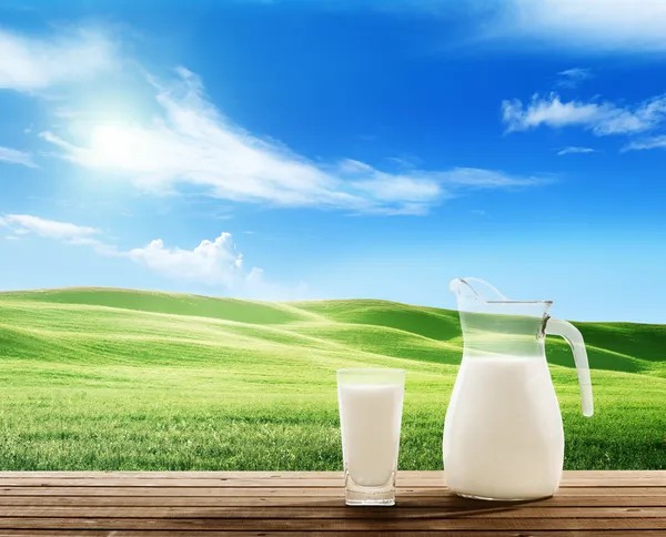 Milk and sunny spring field — Stock Photo, Image