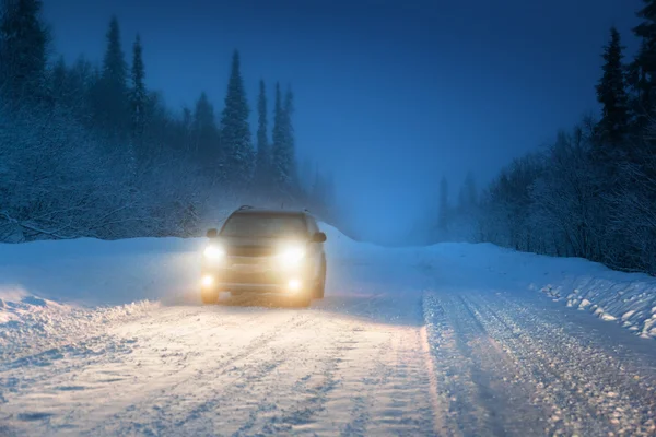 Luzes de carro no inverno floresta russa — Fotografia de Stock
