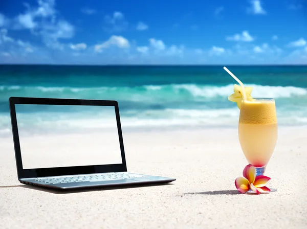 Portátil en la playa y un vaso de jugo fresco — Foto de Stock