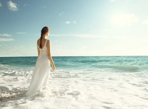 Joven mujer de pie en olas del mar — Foto de Stock