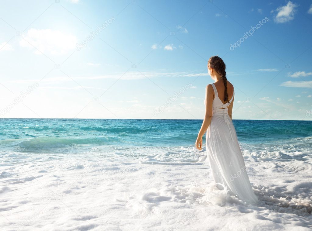 young woman standing in sea waves 