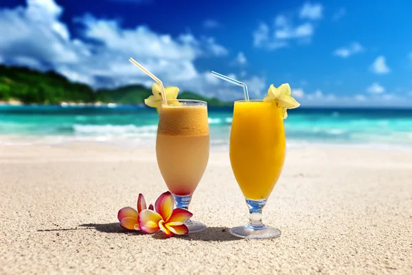 Zumos de frutas frescas en una playa tropical — Foto de Stock