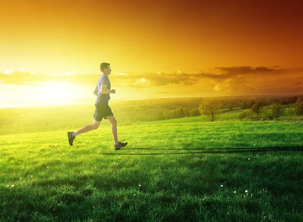 Pôr do sol e correndo jovem — Fotografia de Stock