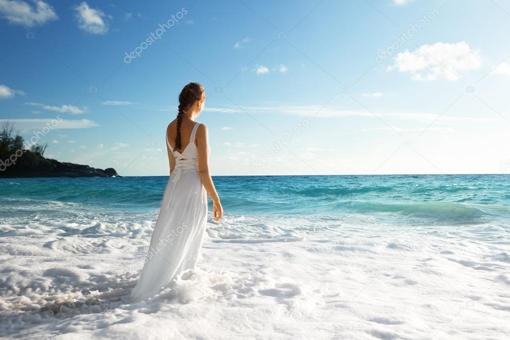 young woman standing in sea waves 