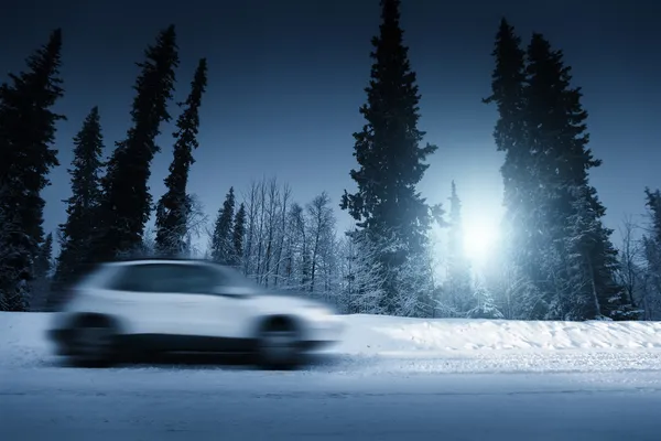 Lights of car and winter road in forest — Stock Photo, Image