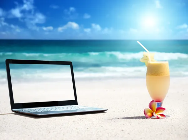 Portátil en la playa y un vaso de jugo fresco —  Fotos de Stock