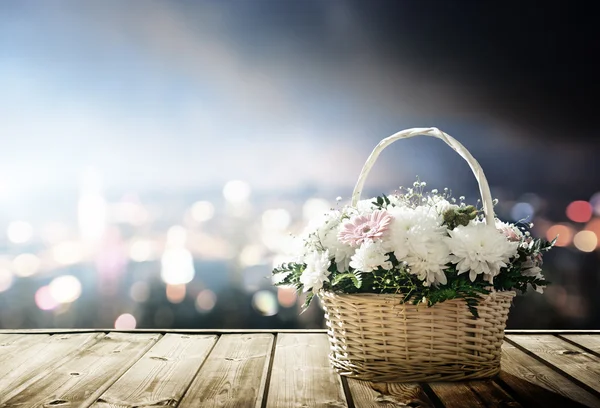 Flores en cesta y luces de la ciudad nocturna — Foto de Stock