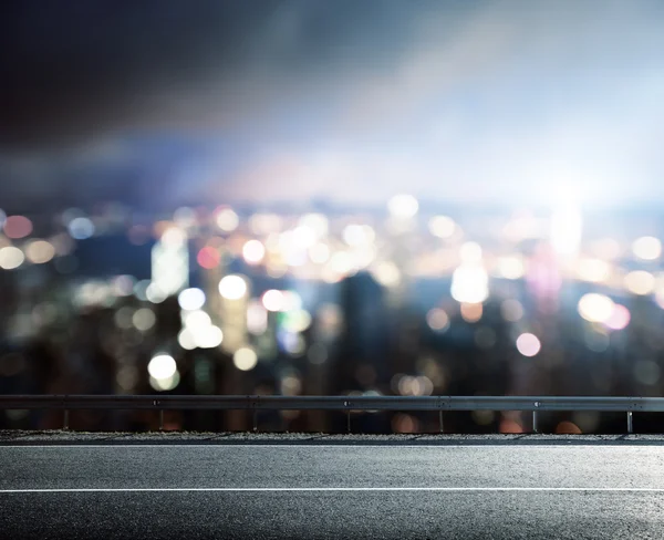 Asphalt road and blurred modern city — Stock Photo, Image