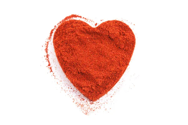 Pile di terra Paprika isolato a forma di cuore su bianco — Foto Stock