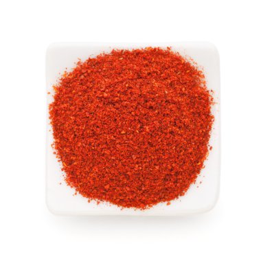 Paprika ground in a white bowl on white background. clipart