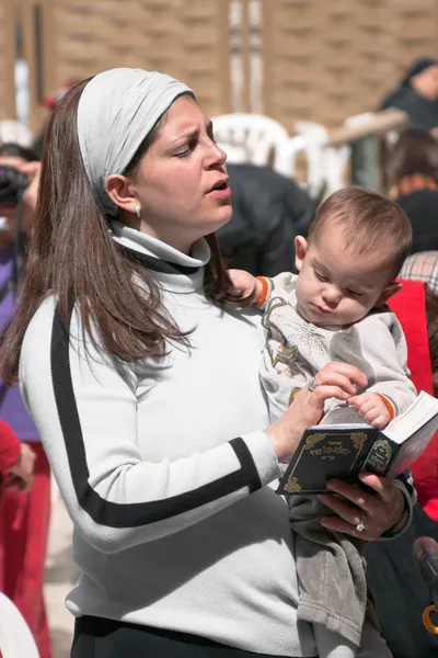 JERUSALEM, ISRAEL - 14 de marzo de 2006: Una mujer con un hijo reza en —  Fotos de Stock