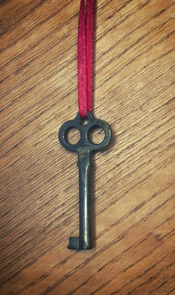 Old key on a red ribbon — Stock Photo, Image