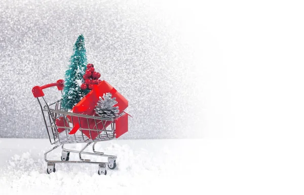 クリスマス 新年の背景 赤いギフトボックスのスーパートロリー シルバーコーン トウヒの木 灰色の背景 クローズアップ ストック写真