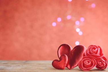 Sevgililer günü, iki kırmızı kalp, ahşap masada güller, yakın plan, bokeh, seçici odak