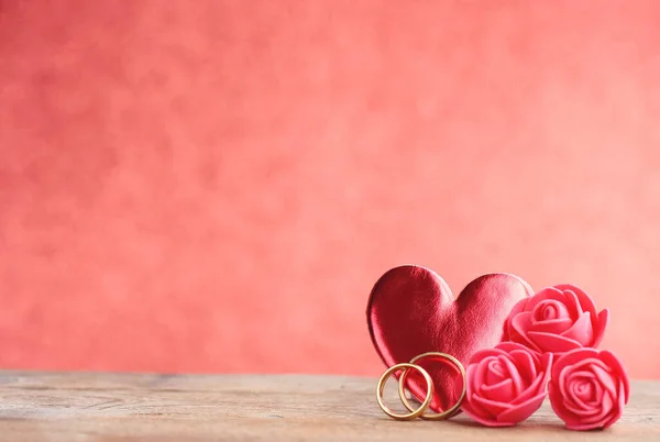 バレンタインデー2つの結婚指輪赤いハート木のテーブルの上のバラクローズアップ選択的フォーカス — ストック写真