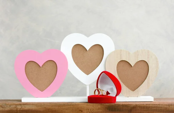 ハート型の写真フレーム木製のテーブルに結婚指輪付きの赤いギフトボックスバレンタインデー結婚式のコンセプト — ストック写真